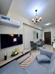 a living room with a couch and a tv at THE PALLADIUM- Serene in Iloilo City
