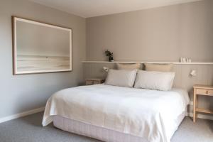 a bedroom with a large white bed and a mirror at Matilda Rose - BYO LINEN AND TOWELS in Rosebud