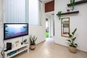 a living room with a flat screen tv on a wall at צימר פרטי בבוגרשוב VIp אופציה לחניה in Tel Aviv