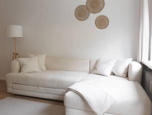 a white couch in a white room with a window at Cozy, Quiet Munich City Apartment in Munich