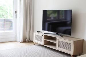 a flat screen tv sitting on a stand in a living room at Cozy, Quiet Munich City Apartment in Munich