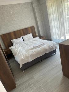 阿馬斯拉的住宿－EGE SUİT OTEL，一间卧室配有带白色床单和枕头的床。
