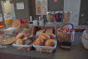 un mostrador con cestas de diferentes tipos de pan y huevos en Hotel Frohnhauser Hof, en Essen