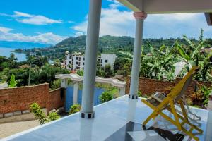 einen Blick vom Balkon eines Hauses mit gelbem Stuhl in der Unterkunft Green Safaris Apartment in Rubavu