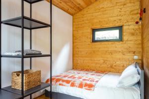 1 dormitorio con 1 cama y pared de madera en Gergeti Trio en Kazbegi