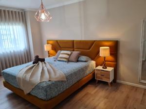 a bedroom with a large bed with a brown headboard at Diamante house com garagem privada in Braga