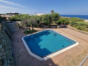 una grande piscina in un cortile vicino all'oceano di Il Paradiso nascosto a Pantelleria