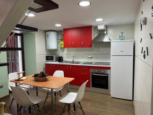 a kitchen with red cabinets and a table and chairs at Alojamientos Peña del Rey in Cazorla