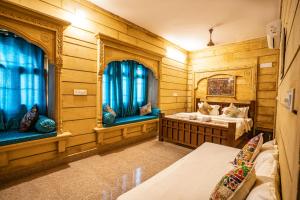 a room with two beds and two windows at Hotel Relax Inn Jaisalmer in Jaisalmer