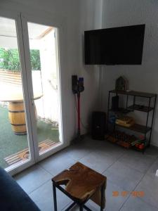 ein Wohnzimmer mit einem TV und einem Tisch in der Unterkunft Baby Home cosy à 1km de la mer in Saint-Cyprien