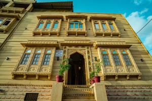 uma casa de madeira com janelas e uma porta em Hotel Relax Inn Jaisalmer em Jaisalmer