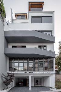 a white building with a sign that reads the universitet at THE URBANIST •inner city residences• in Ioannina