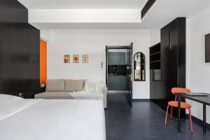 ein Schlafzimmer mit einem Bett und ein Wohnzimmer in der Unterkunft THE URBANIST •inner city residences• in Ioannina