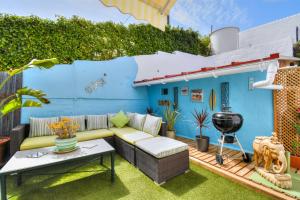 a backyard patio with a couch and a grill at Casa Vista Maroma in Málaga