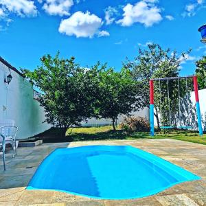 una piscina azul en un patio con un gol en CASINHA AZUL/PIRINOPOLIS en Pirenópolis