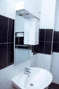 W łazience znajduje się biała umywalka i lustro. w obiekcie Résidence Vedette w mieście Jaunde