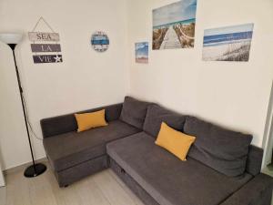 uma sala de estar com um sofá e quadros na parede em Merluza na Nazaré