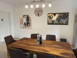 a wooden table with chairs and a clock on the wall at Moderne Wohnung mit Stil in Grossgerungs +25 photos