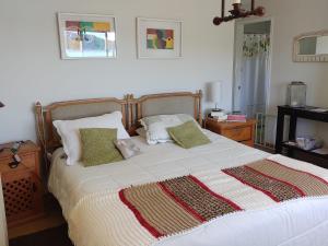 1 dormitorio con 1 cama blanca grande con almohadas en Hermosa Casa en Lago Rapel, en Las Cabras