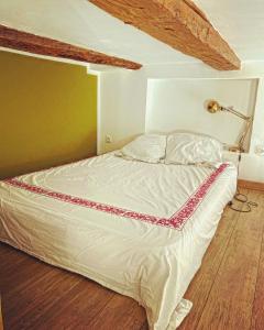 a bed in a bedroom with a lamp on a wooden floor at Vaste loft plein de charme au cœur de Marseille in Marseille