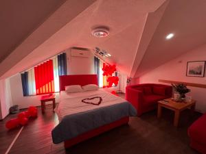 a bedroom with a large bed and a red couch at Prenoćište SAMIR in Gradačac