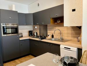una cocina con armarios grises y una encimera con copas de vino en Cœur de Concarneau, en Concarneau