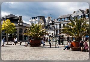 un grupo de personas sentadas en bancos en una plaza de la ciudad en Cœur de Concarneau, en Concarneau