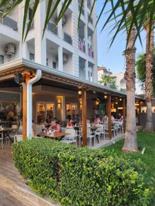 a restaurant with people sitting at tables in front of a building at Esperanza Hotel in Antalya