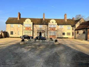 a large building with two cars parked in front of it at 3 Bed Apartment Sleeps 6 Country House in Warwick in Warwick