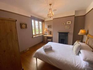 a bedroom with a white bed and a chandelier at 3 Bed Apartment Sleeps 6 Country House in Warwick in Warwick