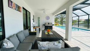 a living room with a couch and a swimming pool at The Salt Life Get Away - Cape Coral, Florida in Cape Coral