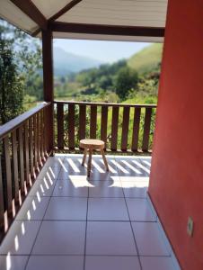 um pequeno banco sentado numa varanda com vista em Refugio Das Pedras em Paraty