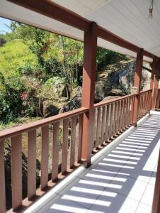 uma varanda de madeira com vista para um rio em Refugio Das Pedras em Paraty
