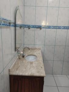 La salle de bains est pourvue d'un lavabo et d'un mur carrelé. dans l'établissement Refugio Das Pedras, à Parati