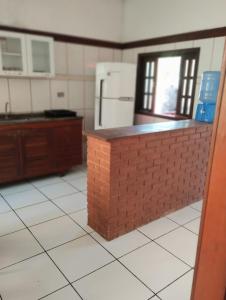 uma cozinha com um balcão de tijolos e um frigorífico em Refugio Das Pedras em Paraty