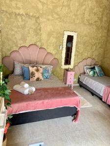 um quarto com uma grande cama rosa e um espelho em Gruta da Sereia Suítes Ubatuba em Ubatuba