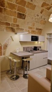 a kitchen with a counter and stools in a room at Iris apartments in Monopoli