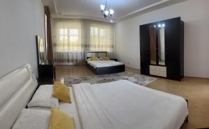 a large bedroom with two beds and a couch at Просторная и уютная 3х комнатная в центре! in Uralsk