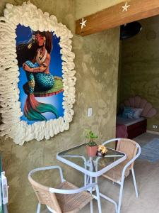 Habitación con un mural de sirena en la pared en Gruta da Sereia Suítes Ubatuba en Ubatuba
