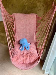 a stuffed blue teddy bear sitting in a hammock at Gruta da Sereia Suítes Ubatuba in Ubatuba