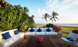 a patio with a white couch and a view of the ocean at Sunny Vacation Villa No 64 in San Rafael del Yuma