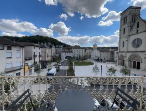 - un balcon avec vue sur une ville et une église dans l'établissement Carnot place, à Bourgoin-Jallieu