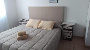 a teddy bear sitting on a bed with two night stands at Complejo Kalifornia in Pilar