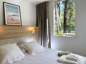 a bedroom with a white bed with a window at Green Resort in Ondres