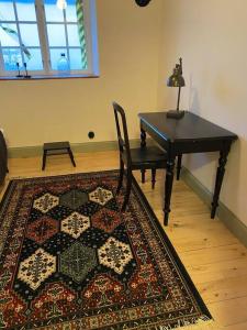 Cette chambre comprend une table, une chaise et un tapis. dans l'établissement 10 min från Malmö/Lund, à Staffanstorp