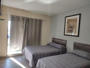1 Schlafzimmer mit 2 Betten und einem Fenster in der Unterkunft Hotel Posada California in Aguascalientes