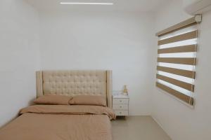a white room with a bed and a dresser and a window at Joanna's Place in Naga +5 photos