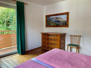 a bedroom with a bed and a dresser and a window at Haus Widmann in Scheffau am Wilden Kaiser
