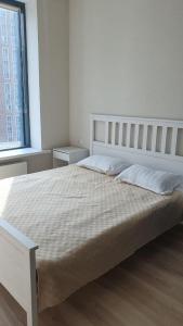 Стильная квартира в ЖК бизнес класса AVENUE 5 في أستانا: غرفة نوم بيضاء مع سرير كبير مع وسائد بيضاء