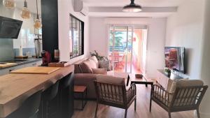 a living room with a couch and a table at Aires de Doñana. Piscina y Playa. Parking gratis. in Sanlúcar de Barrameda